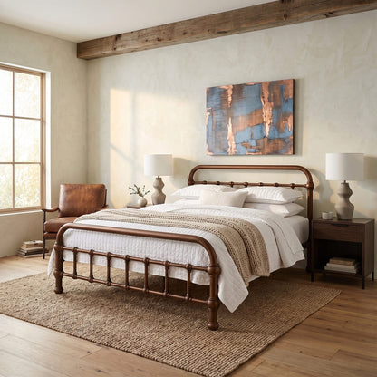 20th c Americana Low Profile Iron Platform Bed by Heiressy. A dark brown metal bed frame with turned spindle-style legs, styled in a rustic bedroom with white bedding, a textured beige throw blanket, a brown leather armchair, and a blue and copper abstract painting on the wall.