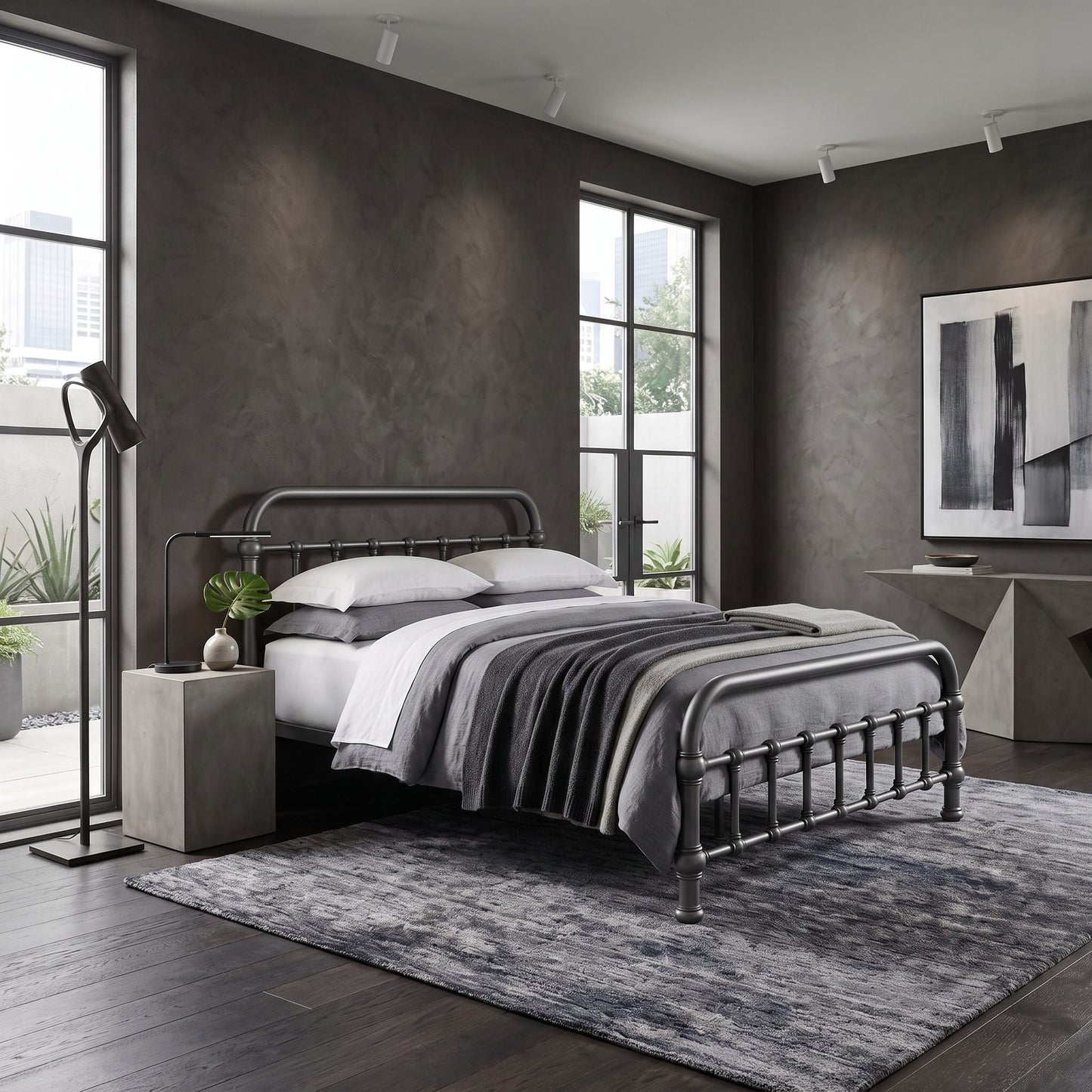 20th c Americana Low Profile Iron Platform Bed by Heiressy. A modern bedroom featuring a dark metal bed frame with a black metal headboard and footboard, styled with gray and white bedding, a gray patterned area rug, and a gray side table with a black floor lamp.