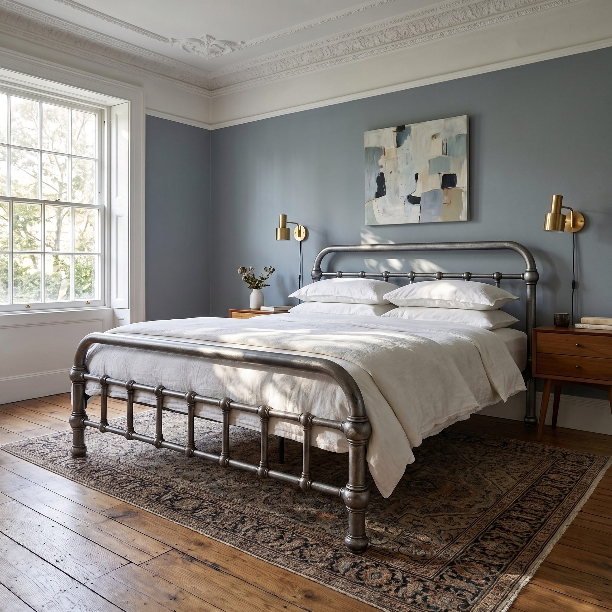 20th c Americana Low Profile Iron Platform Bed by Heiressy.  A metal bed frame with a curved footboard and headboard stands in a styled bedroom with white bedding, a patterned area rug, wooden floors, and blue-gray walls.