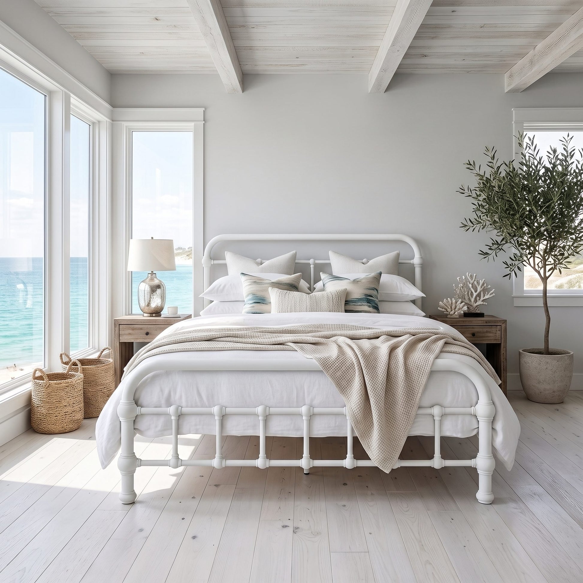 20th c Americana Low Profile Iron Platform Bed by Heiressy.  A white metal bed frame with a classic turned spindle foot design, styled with white linens, beige pillows, and a beige throw blanket in a bright, modern beach-style bedroom.