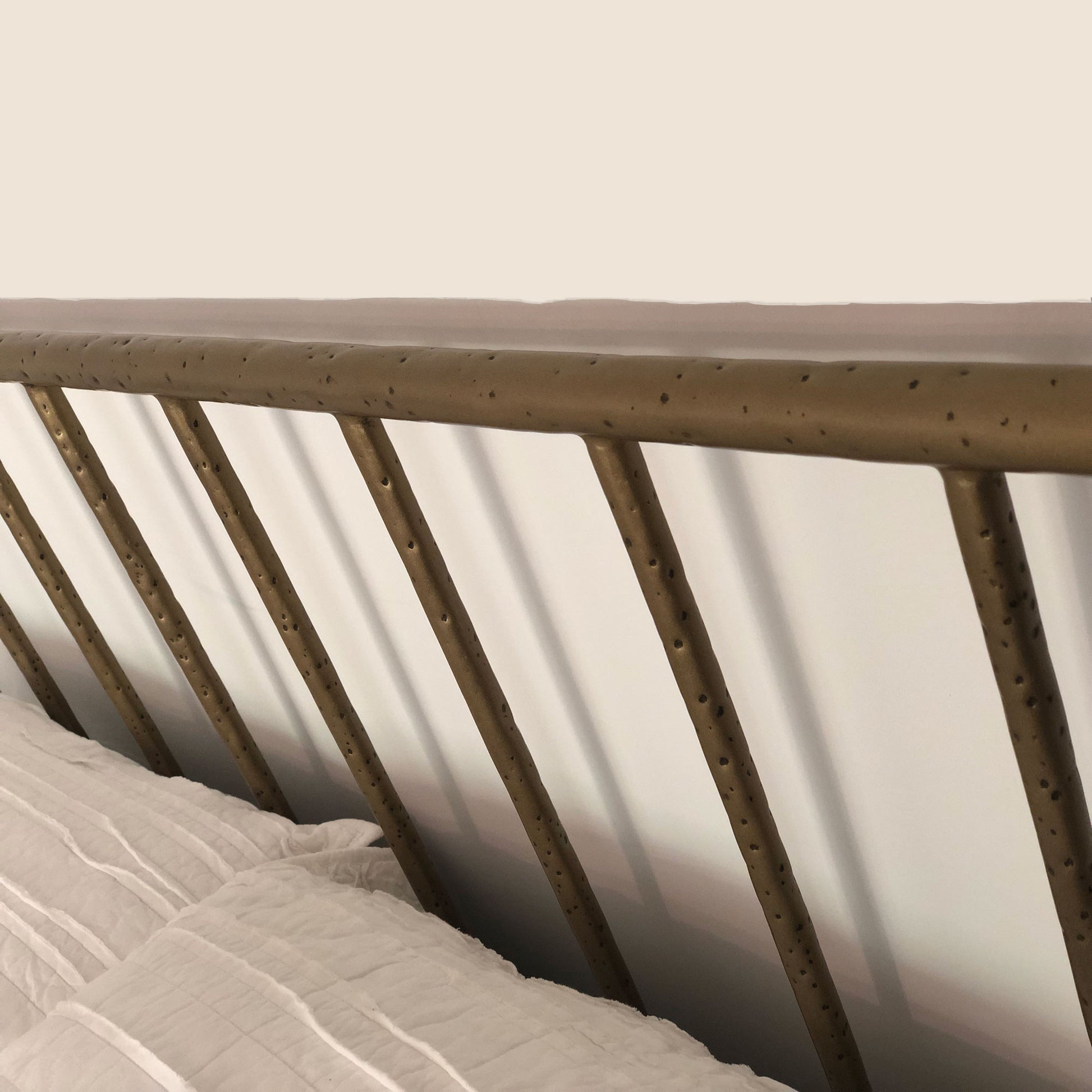 Archaeo Pitted Brass Hammered Iron Platform Bed by Heiressy closeup high-end luxury hammered iron headboard texture furniture.